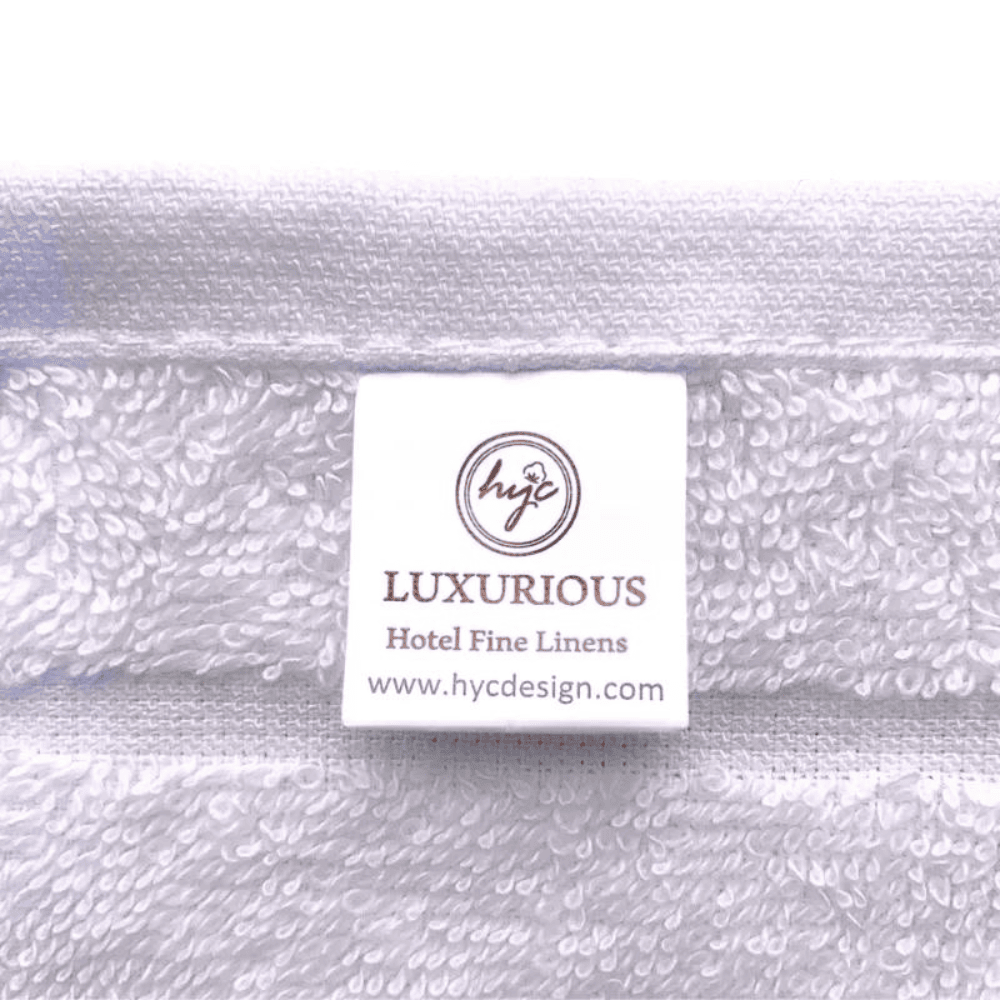 White cotton washcloth neatly displayed, highlighting a refined striped design and a plush, skin-friendly feel