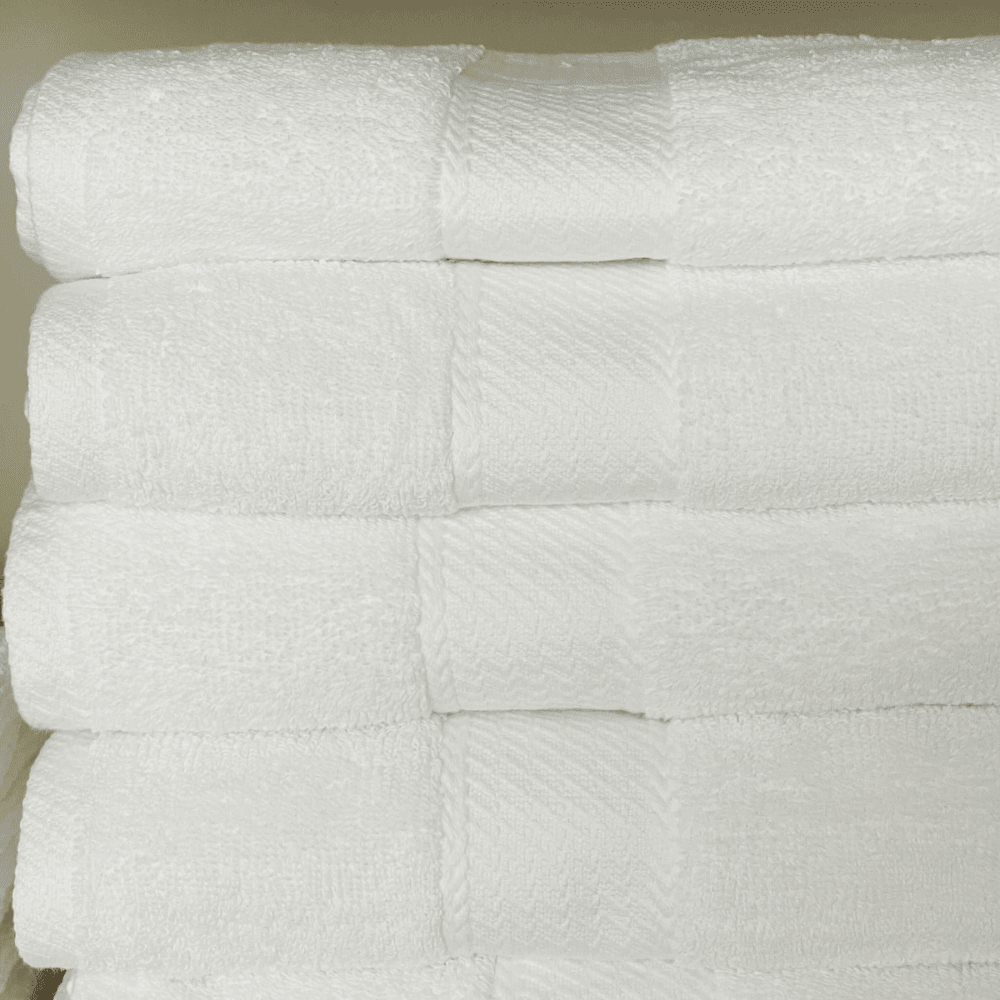 White bath towels styled neatly to reflect a premium, vacation-inspired comfort and timeless design