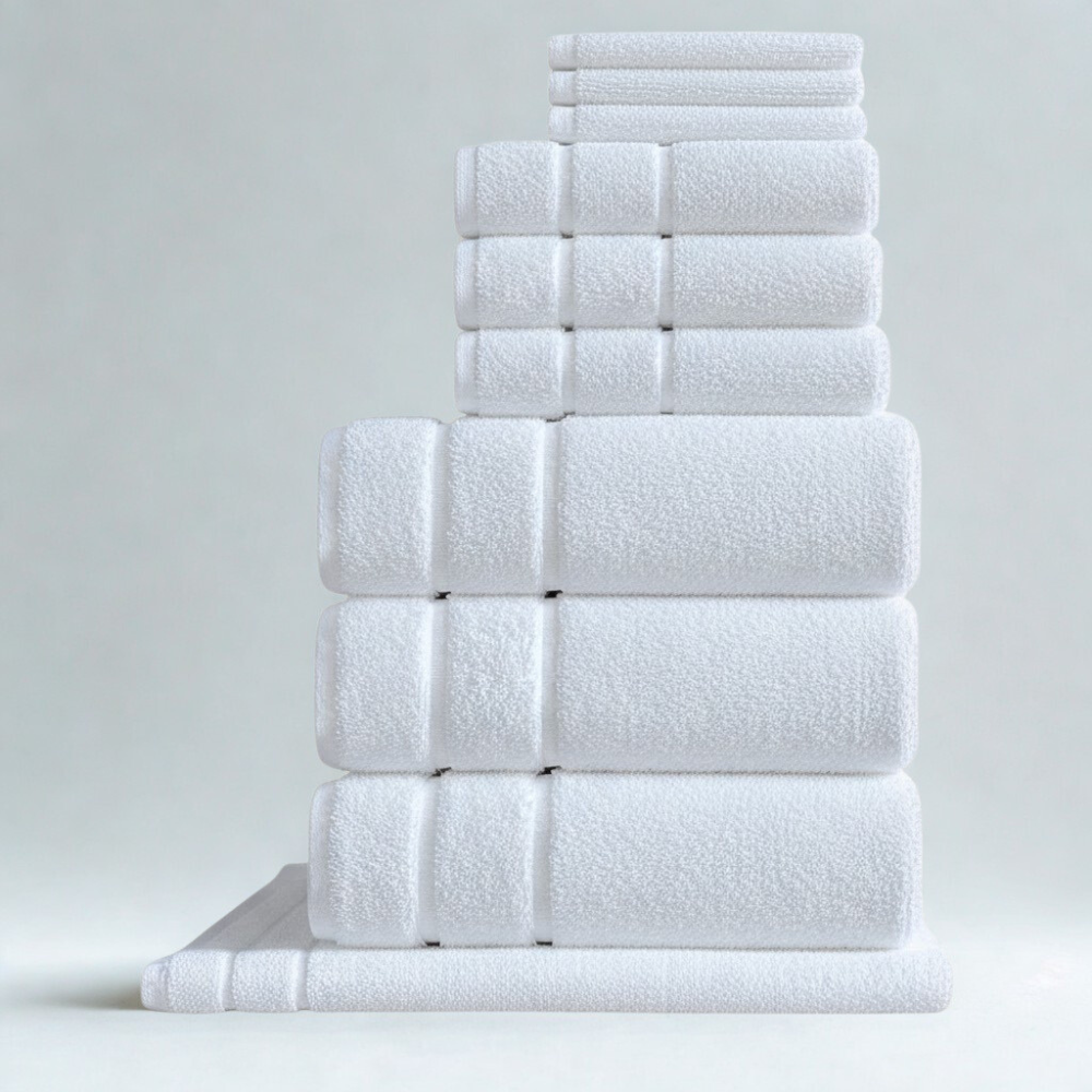 Soft plush white cotton bath towel set with folded bath towels and hand towels stacked neatly.