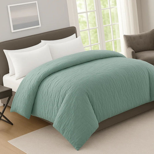 Dusty mint crinkle prewash duvet on a neatly made bed with white pillows, creating a clean, modern and relaxing bedroom style.