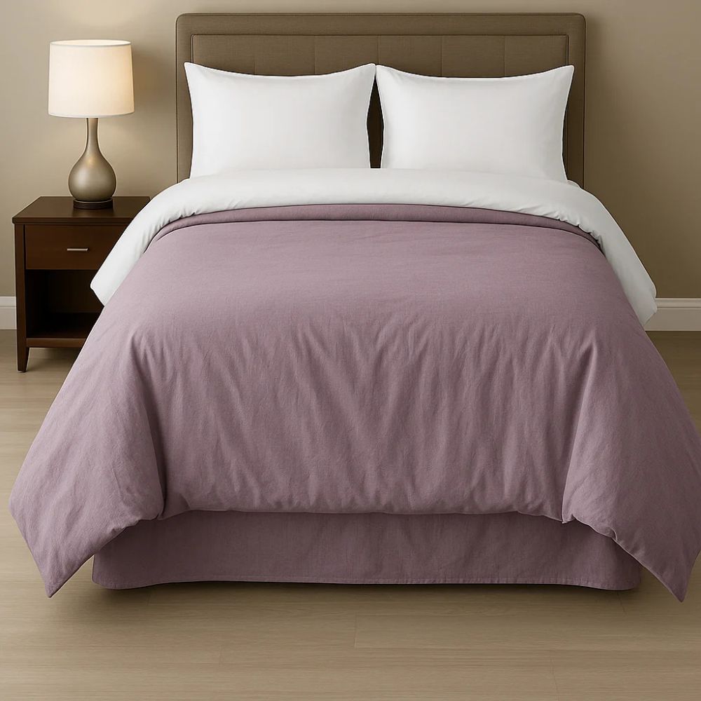 Lavender comforter styled on a neatly made bed with crisp white pillows and bedding for a soft, elegant bedroom look.