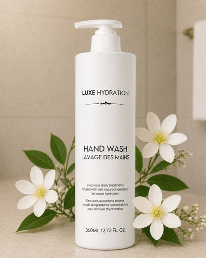 Luxe Hydration 360 ml hand wash bottle displayed with white flowers and green leaves for an elegant, refreshing bathroom presentation.