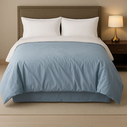 Chambray blue comforter displayed on a neatly made bed with white pillows, creating a calm and refreshing bedroom look.