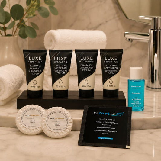 Luxe Hydration Fragrance bathroom amenity collection with toiletries, two guest soaps, FreshMint mouthwash and makeup remover wipe.