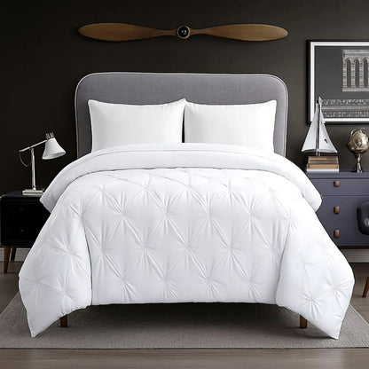 White pinch-pleat comforter styled on a modern bed with crisp white pillows for a clean, bright and luxurious bedroom appearance.