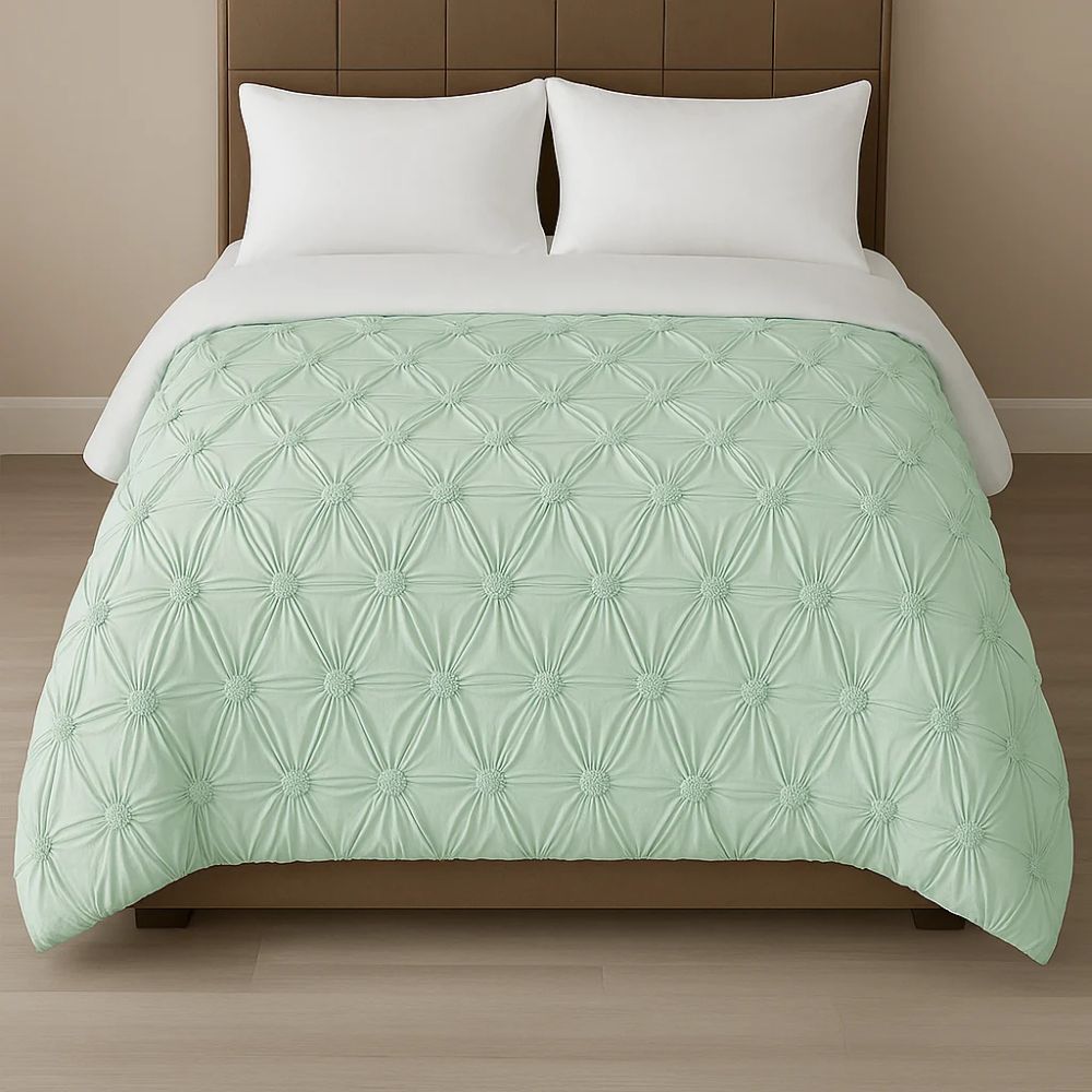Pale blue pinch-pleat comforter paired with white pillows for a fresh, calming bedroom appearance.