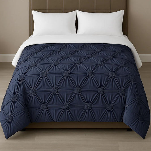 White pinch-pleat comforter styled on a modern bed with crisp white pillows for a clean, elegant bedroom look.