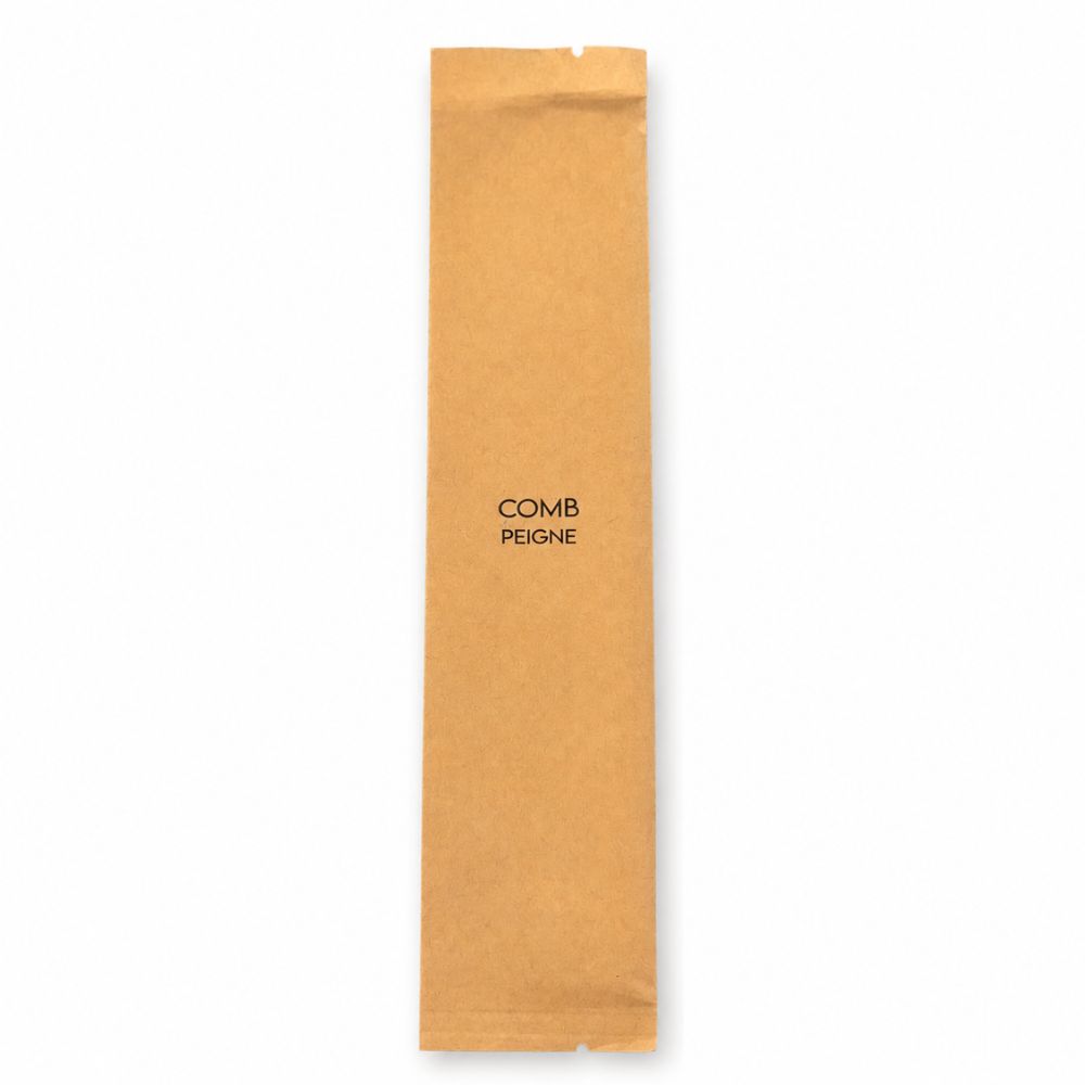 Individually wrapped white comb in a kraft paper sleeve labelled Comb and Peigne for hygienic travel and personal care.