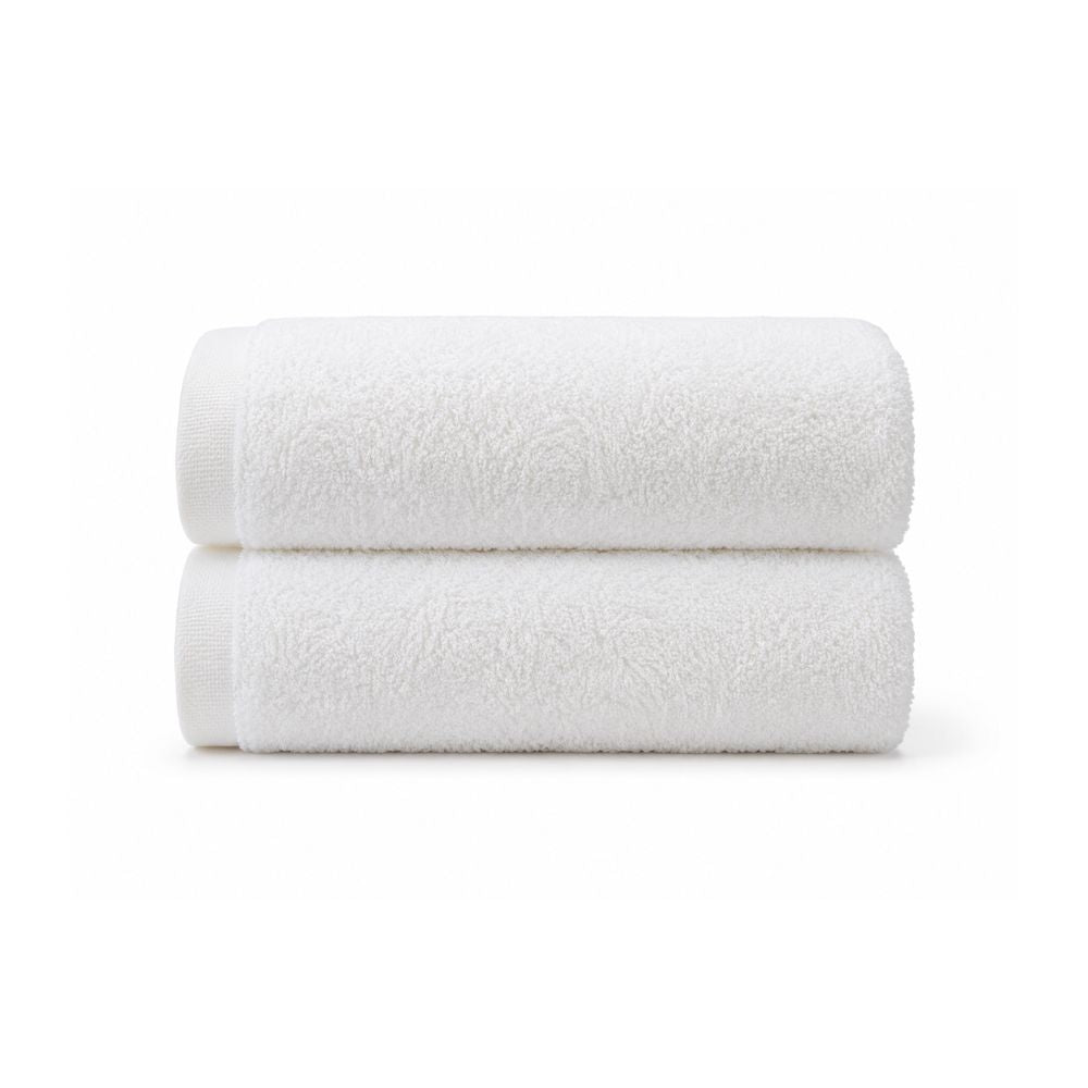 Soft white bath towel laid flat on a clean white background, showing its smooth terry texture and simple border for everyday bathroom use.