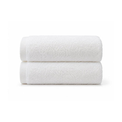 Soft white bath towel laid flat on a clean white background, showing its smooth terry texture and simple border for everyday bathroom use.