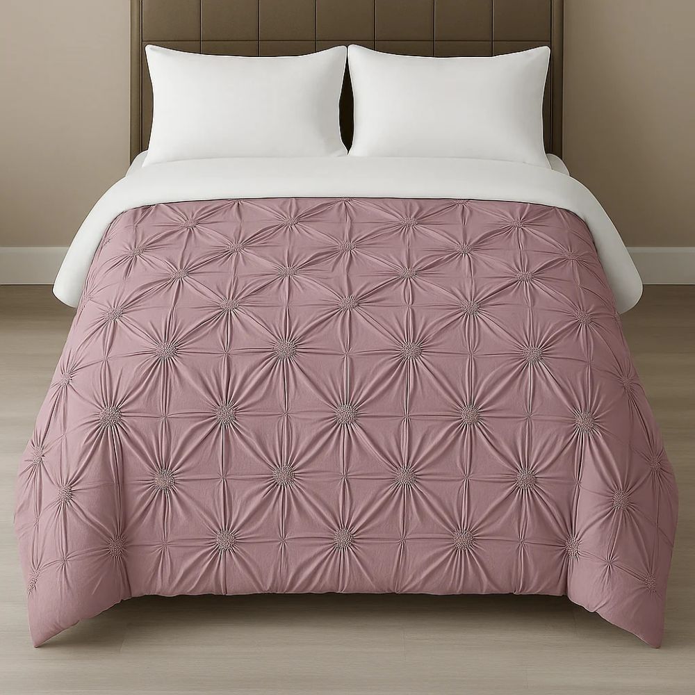 Mauve pinch-pleat comforter styled on a neatly made bed with white pillows for a warm, graceful bedroom look.