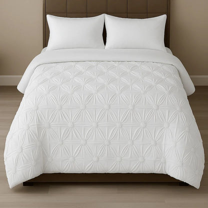 White pinch-pleat comforter styled on a modern bed with crisp white pillows for a clean, elegant bedroom look.