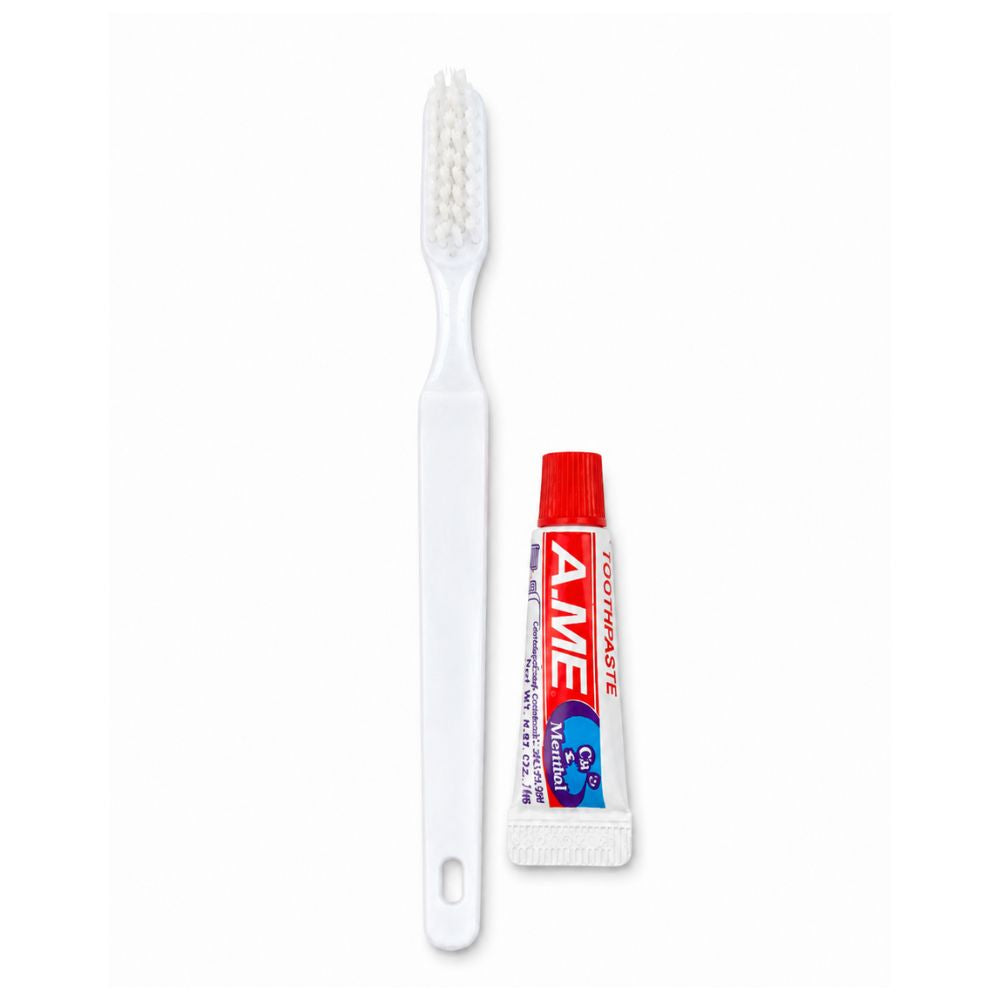 White toothbrush with travel-size mint toothpaste on a clean white background, ideal for guests, travel and everyday oral care.