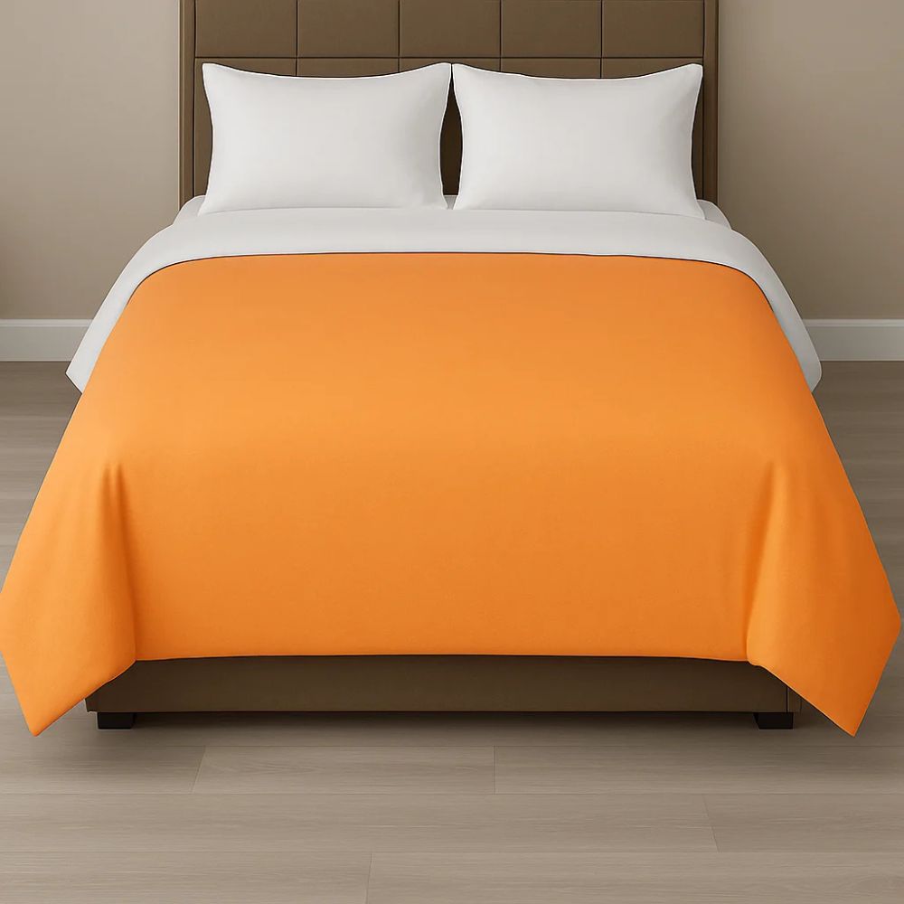 Bright orange duvet cover styled on a modern bed with white pillows for a vibrant and energetic bedroom look.