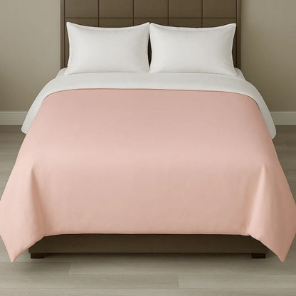 Soft blush pink duvet cover displayed with white pillows for a gentle, elegant and relaxing bedroom style.