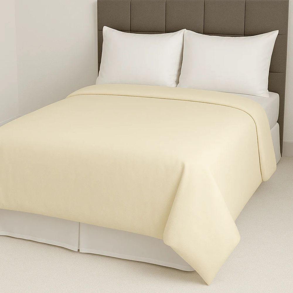 Soft cream yellow duvet cover paired with crisp white pillows for a warm, subtle and inviting bedroom style.