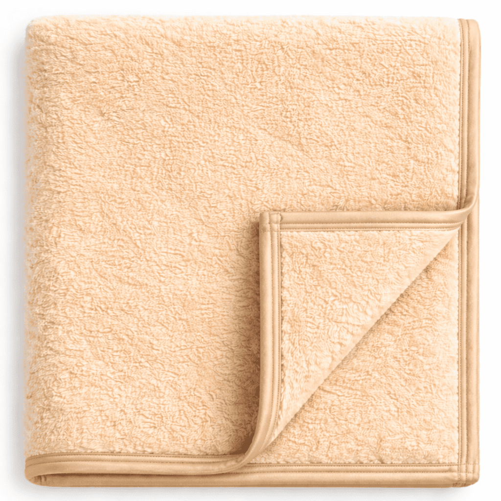 Luxury champagne fleece blanket with piping, warm and comfortable for hotel and guest room bedding.