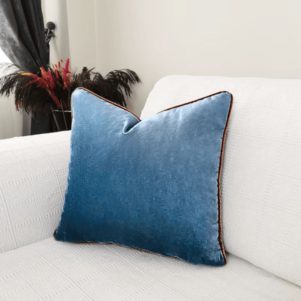 Soft Blue Cushion with brown lining on edges on Sofa