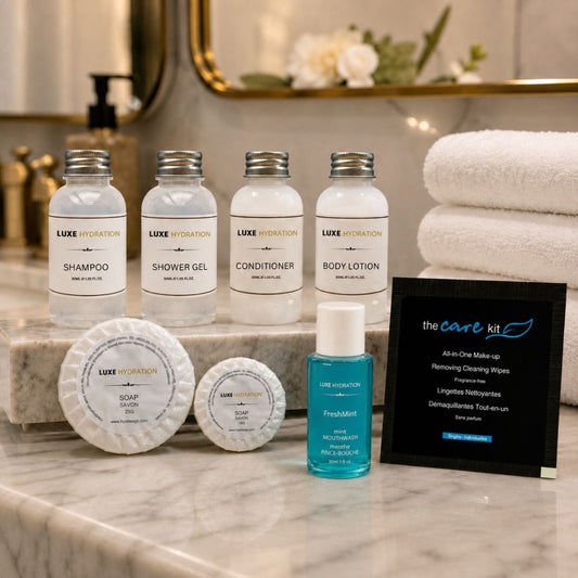 Luxe Hydration bathroom amenity collection with four toiletries, two guest soaps, FreshMint mouthwash and makeup remover wipe.