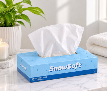 A blue "SnowSoft" deluxe facial tissue box sits on a marble countertop with a soft white tissue pulled from the top.