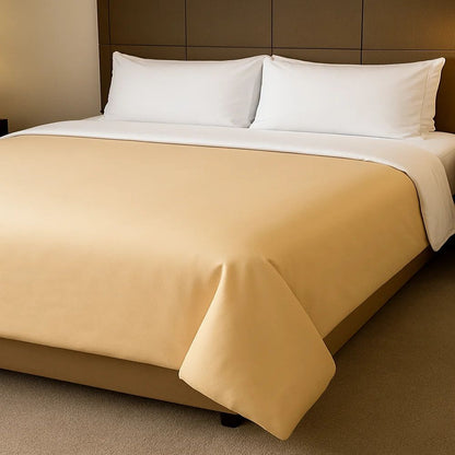 Gold tan duvet cover styled on a neatly made bed with crisp white pillows for a warm and elegant bedroom look.