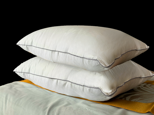 Two king sized pillows stacked on top of each other.