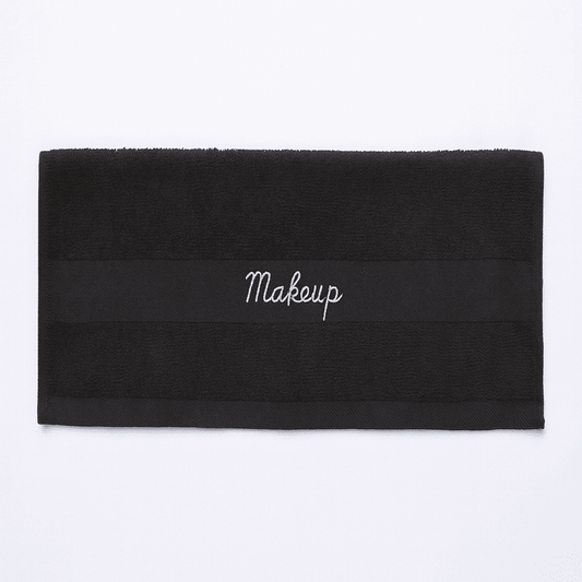 Premium Turkish black makeup towel for hotels, horizontal view showing embroidered band, ideal for guest rooms and spas.