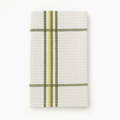 White waffle weave dish towel with green and yellow stripes, neatly folded on white background for hotel use.