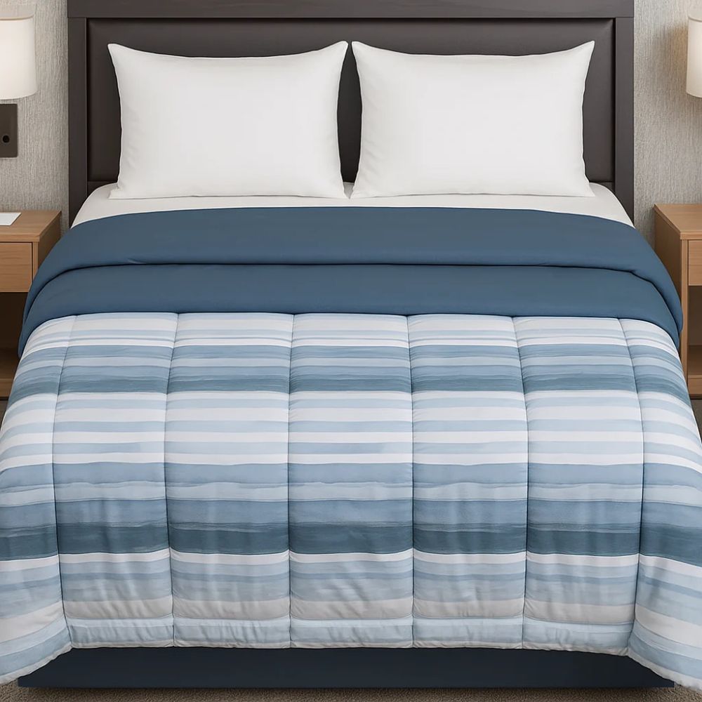 Blue and white striped comforter styled on a neatly made bed with white pillows for a fresh, clean and contemporary bedroom look.